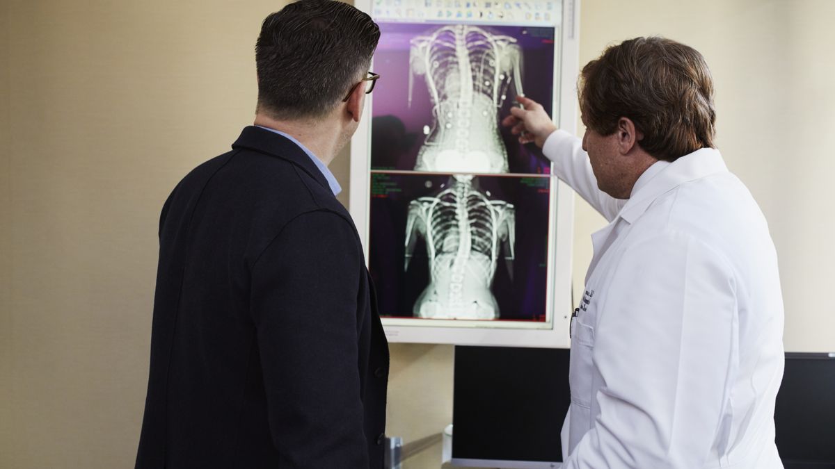 Doctor explaining a scan report to a patient to decide between kidney stone removal and infection treatment