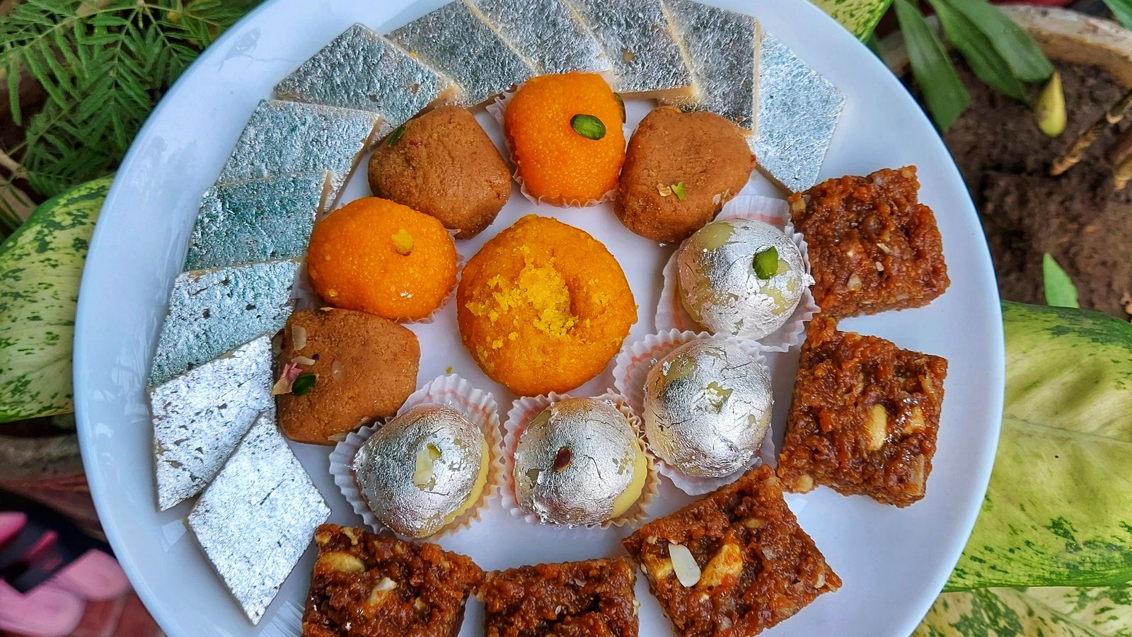Plate of assorted Indian festive sweets including kaju katli, laddoo and barfi served during Diwali
