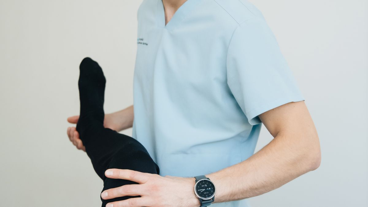 Physiotherapist guiding a patient through a supported leg exercise during joint replacement rehabilitation